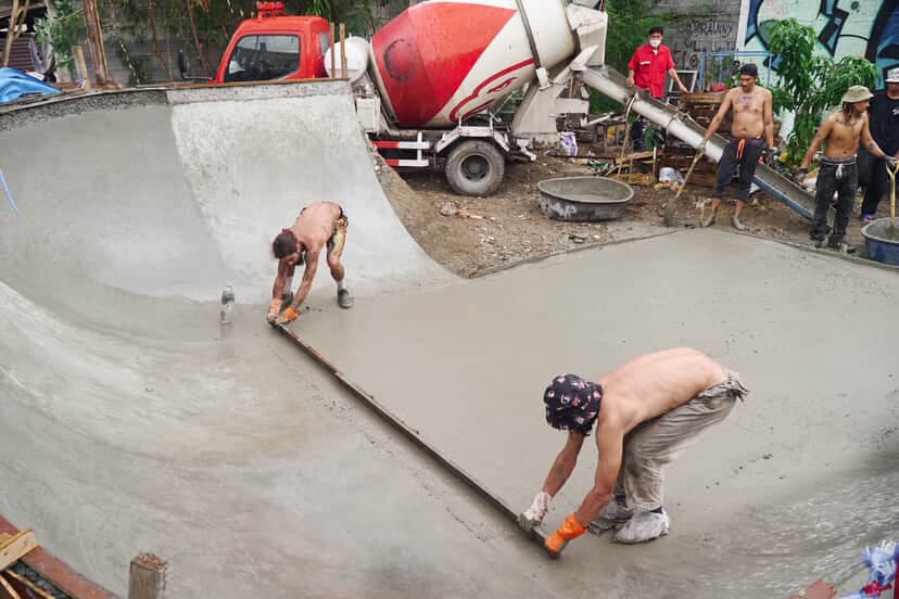 Volunteers pouring concrete with cement mixer
